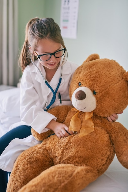 Your heart is healthy and full of love Shot of a little girl pretending to be a doctor while examining her teddybear