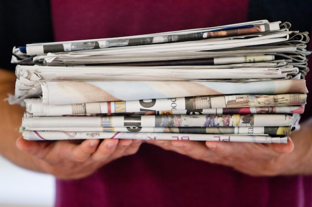 Do your part Cropped shot of a person holding newspapers for recycling