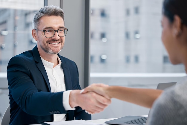 Youre hired Shot of two businesspeople shaking hands in an office