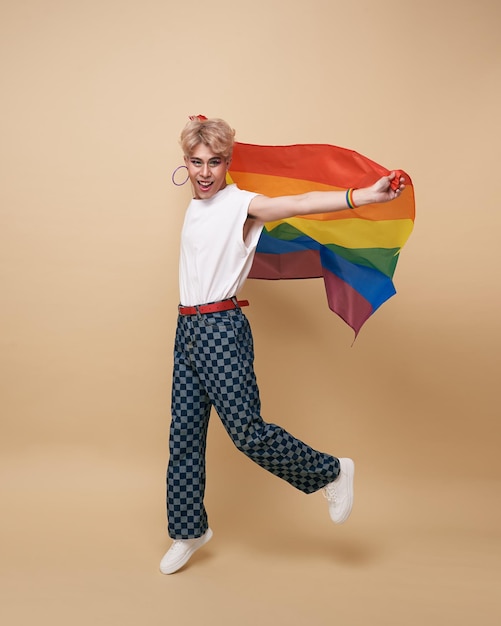 누드 색 배경 위에 고립 된 무지개 깃발을 가진 청소년 아시아 트랜스 젠더 LGBT 게이 프라이드 깃발 개념을 가진 남자