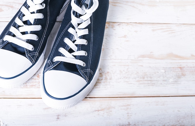 Youth classic gumshoes with white the laces on wooden  background