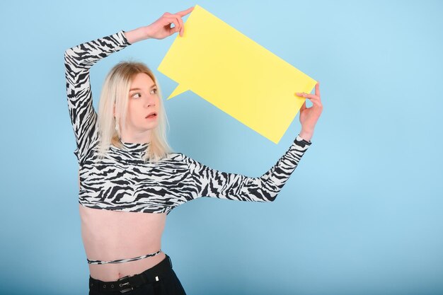 Youth transgender LGBT looking at camera while posing isolated over nude color background