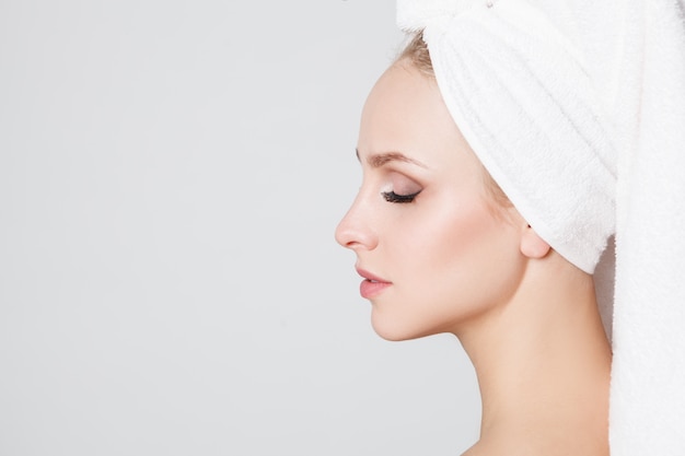 Youth women with towel on her head looking at camera. Indoor. Skincare