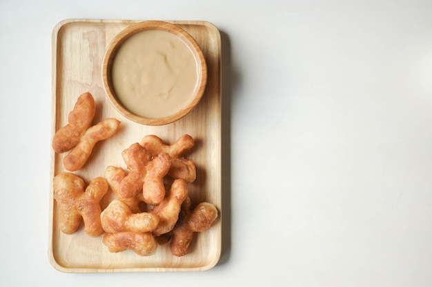 Youtiao or Cakwe with milktea custard on brown wooden background.