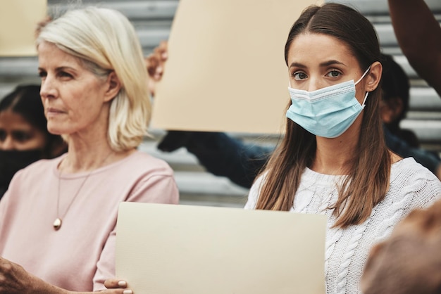 Foto devi lottare per la libertà ritratto ritagliato di una giovane donna attraente che indossa una maschera mentre partecipa a una manifestazione politica