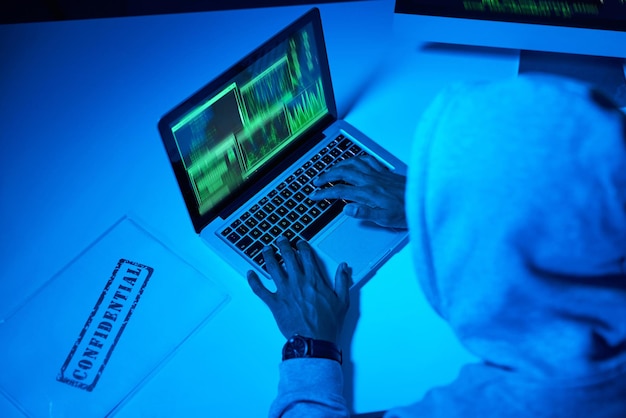 Youve officially been hacked High angle shot of a young male hacker using a laptop in the dark