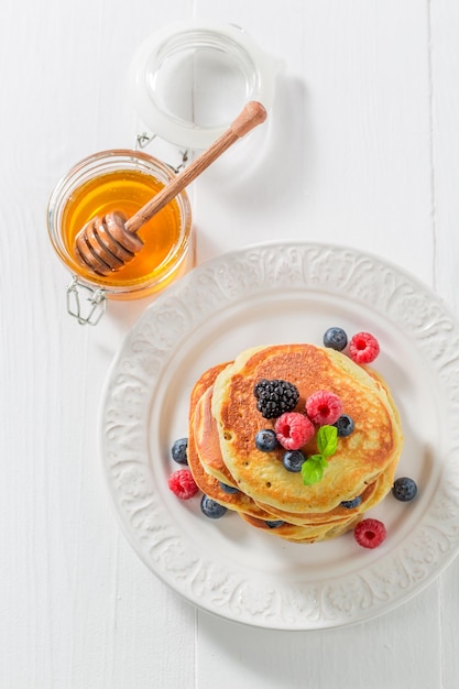 Yummy american pancakes with maple syrup and berries