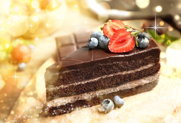 Yummy chocolate cake with berries on plate closeup Tasty dessert for Christmas dinner