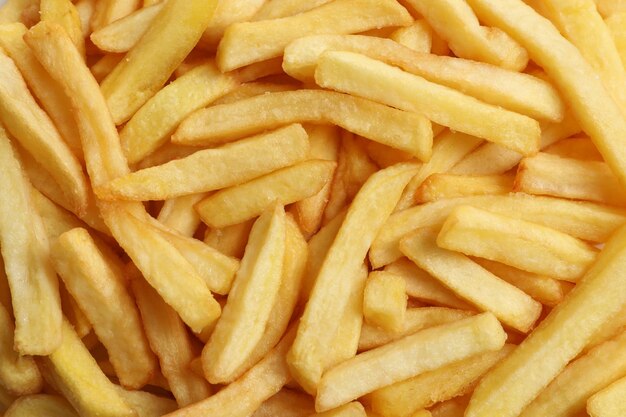 Yummy French fries as background top view