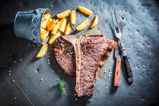 Yummy tbone steak and chips with salt and rosemary