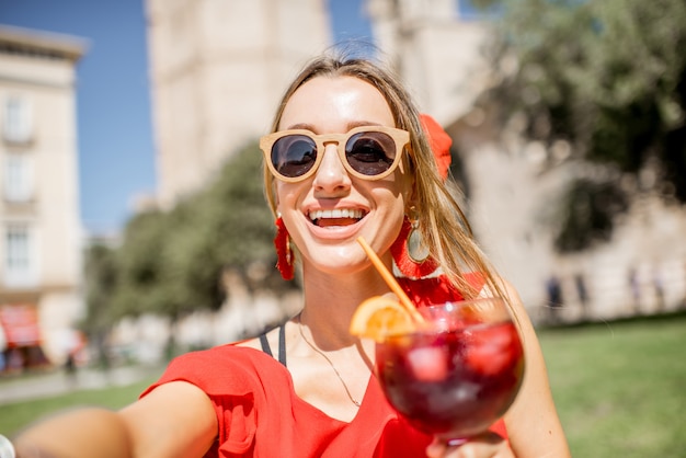 Yuong-vrouw die selfie-foto maakt met sangria, traditionele Spaanse alcoholische drank, buiten in het oude centrum van Valencia