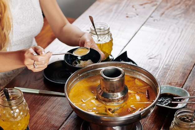 Yuong woman eating delicious squid soup