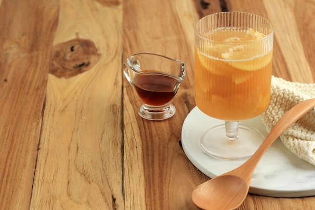 Photo yuzu tea made from yuzu citrus jam and honey. yuja-chhong is a marmalade made from yuzu zest, juice and honey. on wooden table