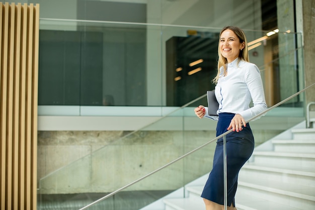 Yyoung business woman walking on stairs in the office hallway