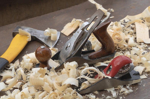 Foto zaagsel op de werktafel met vliegtuiggereedschap en een bijl