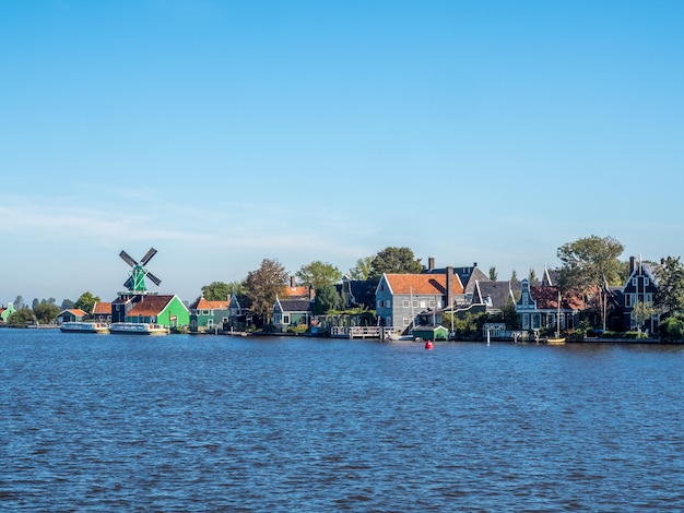 Zaan Schans is popular attractions in Netherlands, has a collection of well-preserved historic windmills and houses, this view from bridge under blue sky