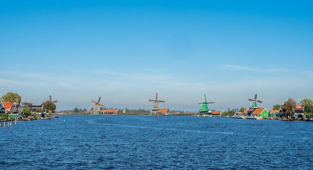 Zaan Schans is popular attractions in Netherlands, has a collection of well-preserved historic windmills and houses, this view from bridge under blue sky