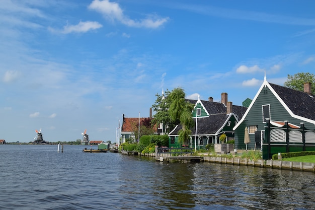 ZAANSE SCHANS, NETHERLANDS, JUNE 19, 2016: Landscape view of the beautiful houses and windmills in Zaanse Schans, Netherlands on June 19, 2016.