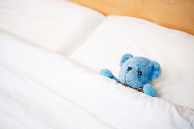 Zacht stuk speelgoed op het bed, teddybeer op een leeg, schoon kinderbed. bed zonder kind