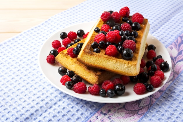 Zachte Belgische wafels met bosbessen, frambozen en zwarte bessen