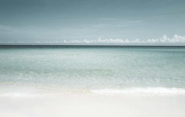 Zachte blauwe oceaangolf op schoon zandstrand