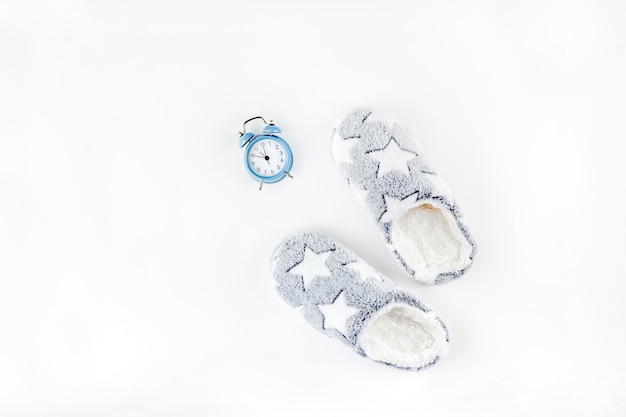 Zachte donzige slippers en blauwe wekker