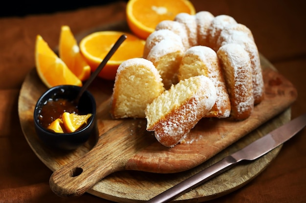 Zachte en luchtige sinaasappelcake met poedersuiker op een houten plank