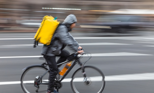 Zachte focus beweging wazig beeld van een koerier voor voedselbezorging levert eten. Lange belichtingstijd. Bewegingsonscherpte afbeelding