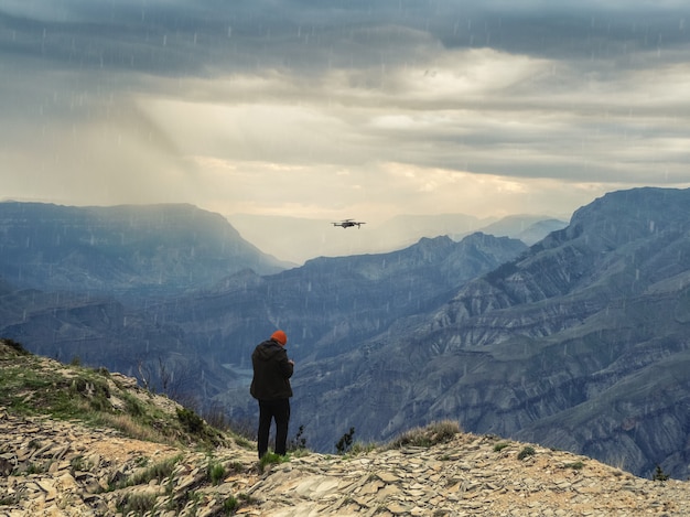 Zachte focus. drone-fotograaf die bij slecht weer een dron start op een klif in de bergen.