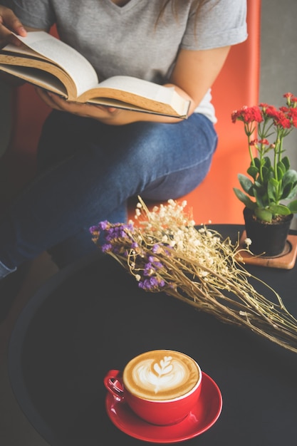 Zachte foto een meisje dat een boek leest en koffie drinkt