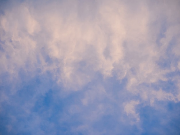 Zachte rokerige wolken op blauwe avondlucht, rustige achtergrond