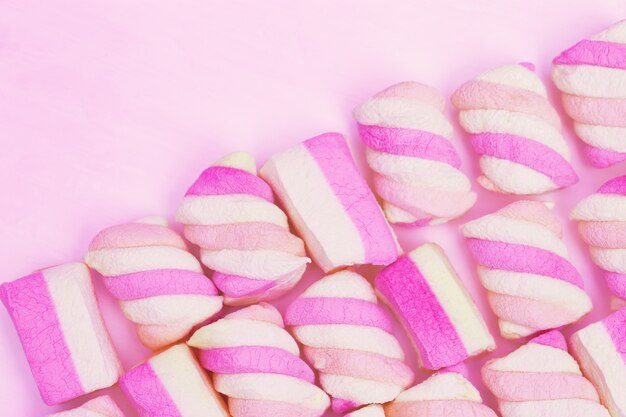 Zachte roze en gele kleur marshmallows op roze achtergrond met kopie ruimte. zoet eten. pastelkleur.