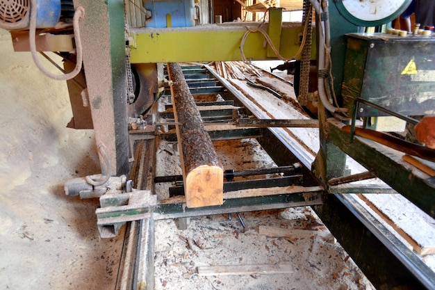 Zagerij. Proces van het machinaal bewerken van logs in apparatuur zagerij machine zag de boomstam op de plank planken. Houtzaagselwerk zagen van hout hout houten houtbewerking