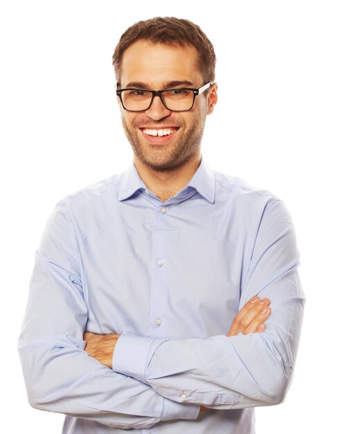 Zakelijk, succesvol en mensenconcept - knappe jonge zakenman in blauw shirt die naar camera kijkt die tegen een witte achtergrond staat