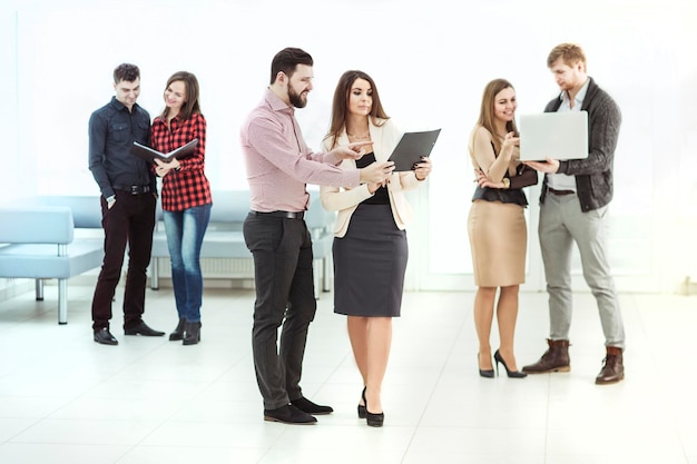 Zakelijk team dat documenten bespreekt die vóór de vergadering in de lobby van het kantoor staan