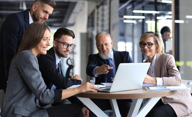 Zakelijk team dat op laptop werkt om de resultaten van hun werk te controleren