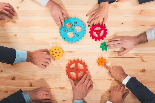 Foto zakelijk team verbindt delen van versnellingen zoals een teamwerk en partners