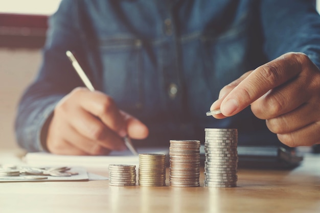 zakelijke accountin met geld te besparen met de hand zetten van munten