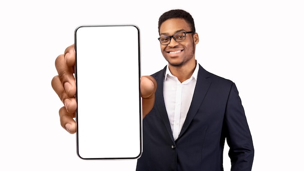 Zakelijke app zwarte jonge zakenman die grote lege smartphone in de hand houdt