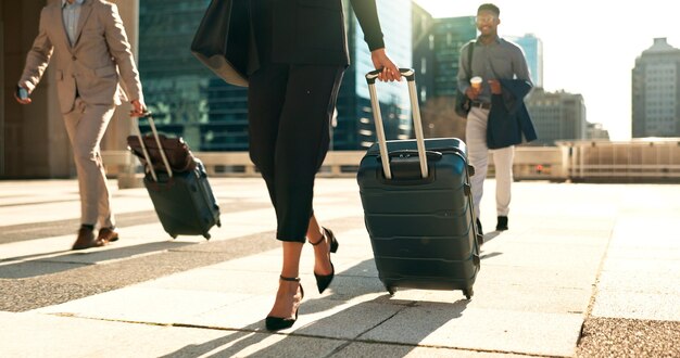 Foto zakelijke benen en bagage voor reizen in de stad met zakelijke mensen die naar een hotel, luchthaven of zakelijke gelegenheid lopen professionele vrouw of man voeten en stappen met koffer buitenshuis op carrièrereis