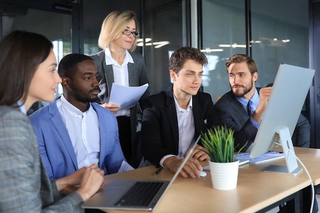 Zakelijke bijeenkomst - manager die het werk bespreekt met zijn collega's.