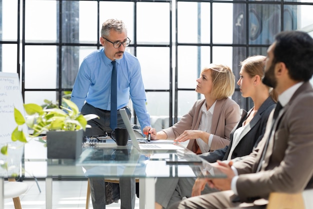 Zakelijke bijeenkomstmanager die werk bespreekt met zijn collega's