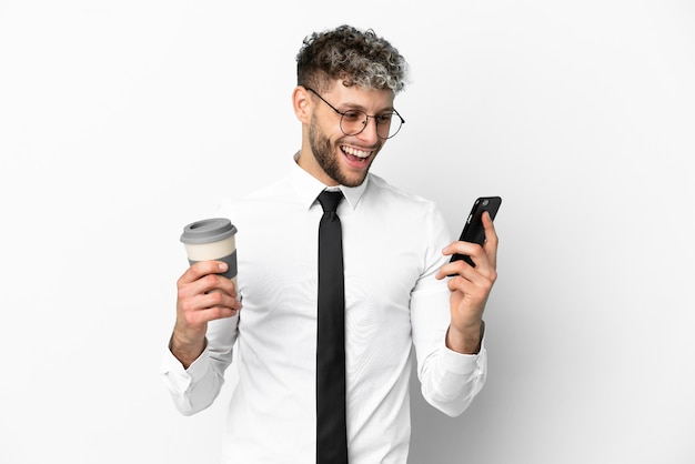 Zakelijke blanke man geïsoleerd op een witte achtergrond met koffie om mee te nemen en een mobiel