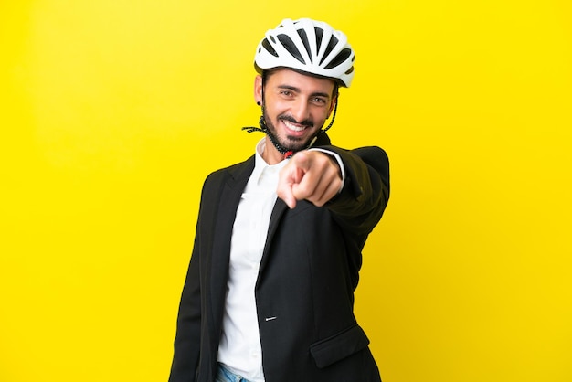 Zakelijke blanke man met een fietshelm geïsoleerd op gele achtergrond wijst vinger naar je met een zelfverzekerde uitdrukking