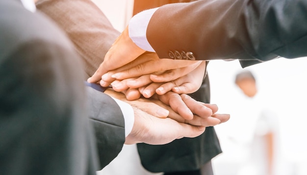 Zakelijke collega's die hun handen buiten stapelen.