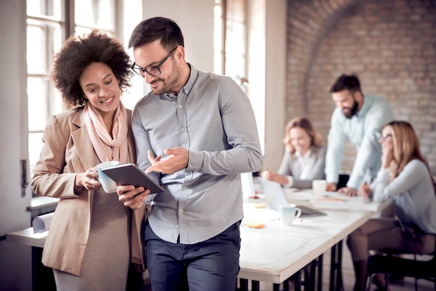 Zakelijke collega's in modern kantoor met behulp van tablet