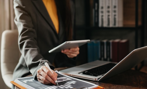 Zakelijke documenten op bureau met laptop en tablet en grafiek bedrijfsdiagram en vrouwen die op kantoor werken