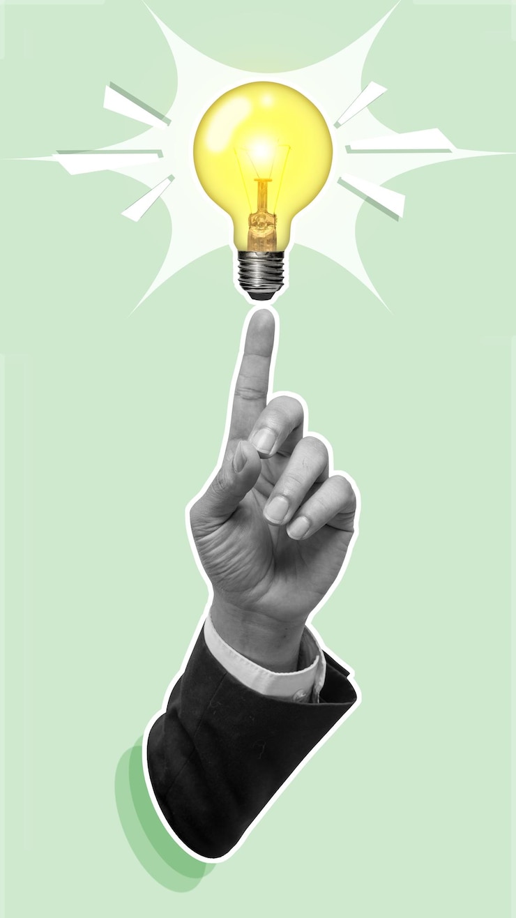 Foto zakelijke hand wijst naar een heldere gloeilamp als symbool van nieuwe ideeën