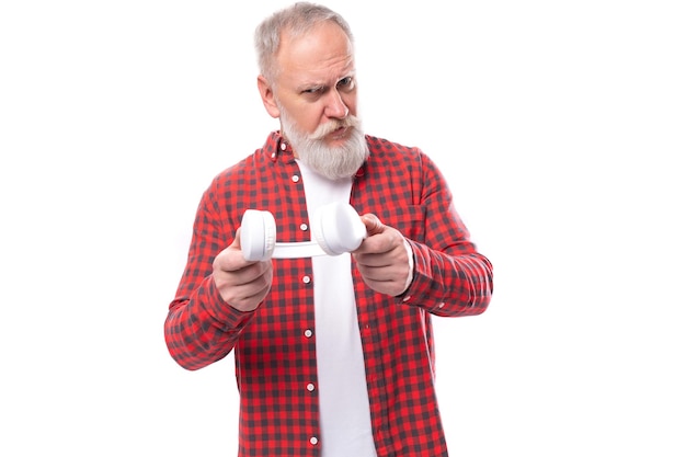 Zakelijke knappe volwassen grijsharige man van middelbare leeftijd met een baard en een koptelefoon