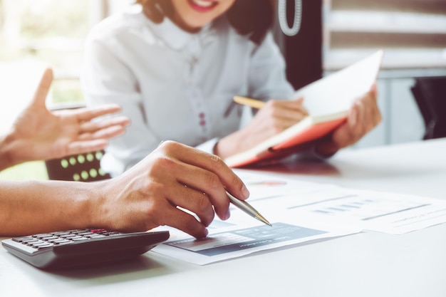 Zakelijke man die toezicht houdt en secretaris om het businessplan uit te voeren en consultant die het jaarlijkse financiële verslag van het bedrijf analyseert balansverklaring werken met documenten grafieken